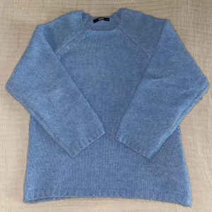 Ljusblå stickad tröja från Bikbok - Mysig ljusblå stickad tröja från Bikbok. Perfekt för våren och sommarkvällar. Tröjan har långa ärmar och ribbade kanter vid ärmslut och nederkant. Storlek XS men oversized i storleken ☺️