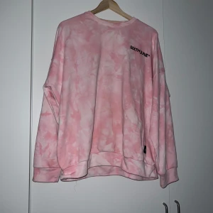 Rosa batikmönstrad sweatshirt från Sixth June - Säljer en cool rosa batikmönstrad sweatshirt från Sixth June. Tröjan har en avslappnad passform med tryck på både fram- och baksidan. Använd ett fåtal gånger men fortfarande i bra skick
