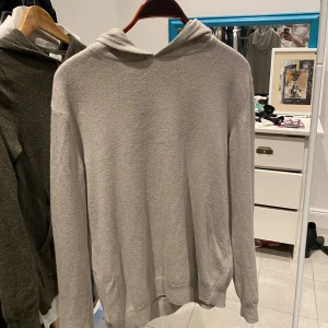 Ljusbeige hoodie från Oscar Jacobson - Säljer en stilren grå hoodie från Oscar Jacobson storlek m men kan nog passa S. Den är  i väldigt bra skick och utan defekter, tillverkad i italien och en blandning mellan merino och kashmir, skriv vid funderingar eller fler bilder