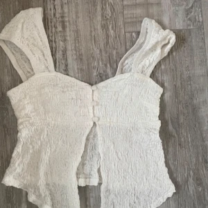 Meotine  - Säljer en stilren grå jacka med en lyxig pälskrage. Jackan har stora fickor framtill och knappar som stängning. Perfekt för kyligare dagar och ger en elegant touch till din outfit.