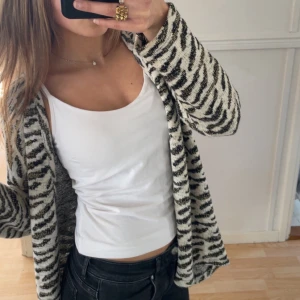 Kofta i zebramönster - Vit kofta i zebramönster med guldiga detaljer, så snygg och enkel att styla. Stl 34 (XS), men sitter mer som en S skulle jag säga💕