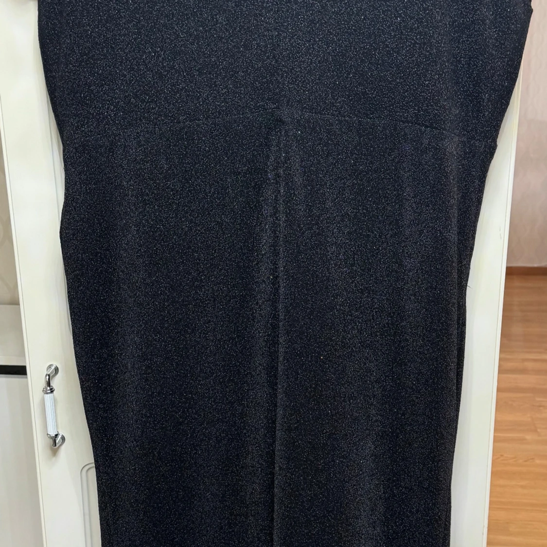 Svart glittrig långklänning med dekorativ detalj - 1