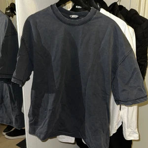 Mörkgrå t-shirt från Zara - Säljer en stilren mörkgrå t-shirt från Zara. Den har en normal passform och är tillverkad i mjukt bomullsmaterial. Perfekt för en avslappnad look.