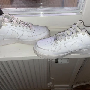 Vita Nike Air Force sneakers - Säljer ett par klassiska vita Nike Air Force sneakers. De har en stilren design med snörning och den ikoniska swoosh-loggan på sidan. Perfekta för en casual look. Köpta för 1499kr på Nike. 