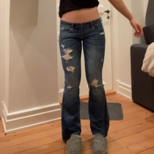 Mörkblå lågmidjade bootcut jeans med slitningar - Säljer dessa mörk blå lågmidjade jeans som är utsydda bootcut. Midjemått är 36 cm tvärs över, grenhöjd 16 cm och de är bra i längden på mig som är 163 cm lång. Kolla gärna min profil säljer fler liknande jeans. Kontakta mig gärna privat vid frågor eller liknande💓