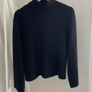 Svart polotröja från Object XS - En svart polotröja från Object i storlek XS. Tröjan har en ribbad hög krage och är långärmad. Enkel och stilren modell som är lätt att matcha med olika outfits. Perfekt för dig som gillar en clean och klassisk look.