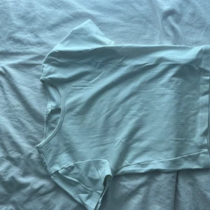 Vit basic t-shirt från Giantcool XS - Enkel och stilren vit t-shirt från Giantcool i storlek XS. T-shirten har rund halsringning och korta ärmar, perfekt för en clean och fräsch look. Tillverkad i mjuk bomull som känns skön mot huden.