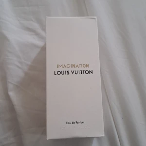 Louis Vuitton Imagination EdP 100ml - Lyxig parfym från Louis Vuitton, Imagination Eau de Parfum i 100ml flaska. Kommer i elegant, rund glasflaska med svart lock och stilren vit förpackning. Doften är exklusiv och modern, perfekt för dig som vill sticka ut med något unikt.