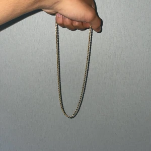 Guld doppade halsband och armband set - Snyggt halsband med tvinnad kedja i guldfärg. Kedjan har en klassisk design som ger en clean och stilren look. Perfekt för att lyfta din outfit med en enkel men elegant detalj. Längden är medellång och låset är smidigt att använda.