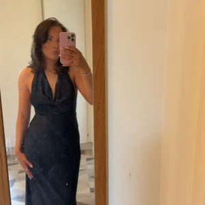 Marinblå långklänning med halterneck - Säljer en jättefin och populär marinblå långklänning med snygg halterneck och djup v-ringning. Klänningen har en elegant, figurnära passform och faller snyggt längs kroppen. Perfekt för bal eller festliga tillfällen.💗