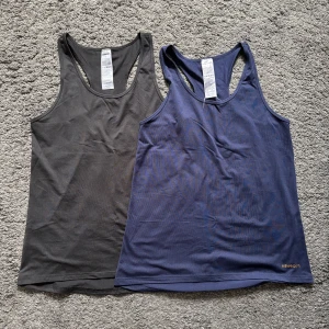 Svart och marinblått träningslinne - Två träningslinnen. Ett svart och ett marinblått. De är relativt lösa i passformen och i princip aldrig använda!