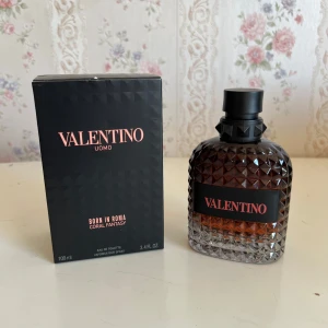 Valentino  Born In Roma Coral Fantasy - Exklusiv herrparfym från Valentino, Born In Roma Coral Fantasy. Flaskan är 100 ml och har en cool, nitar-inspirerad design i glas med svart och korallfärgad toning. Snygg svart kartong med roséguldsdetaljer. Perfekt för dig som gillar lyxiga och trendiga dofter.
