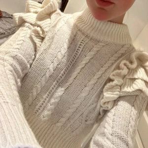 Vit stickad tröja med volang från Gina Tricot - Supersöt vit stickad tröja från Gina Tricot med volangdetaljer på axlarna och kabelstickat mönster. Använd ett fåtal gånger men är i mycket bra skick!😊