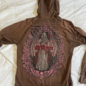 Affliction hoodie vintage rare - Riktigt sällsynt vintage hoodie från affliction, har aldrig sett en liknande. Självklart tecken på användning då det är ett äldre plagg, dragkedjan krånglar lite ibland men bara man lär sig hur man ska göra så är det ingen fara! Hör av er med frågor om ni har dem. Måtten är :68 cm från nacken till botten, 50 cm från armhåla till armhåla och armarna är 77 cm. Vid slutet på armarna, kanten på huvan och på botten så är tyget delat, se bild dessutom finns ett minimalt hål, se bild.