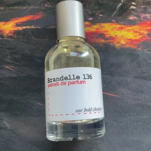 Brandelle 136 Extrait de Parfum - Brandelle 136 Extrait de Parfum från One Bold Chemist. Flaskan är genomskinlig med en silvrig kork och har en minimalistisk vit etikett med svart och röd text. Parfymen har en stilren och modern design, perfekt för dig som gillar unika dofter.