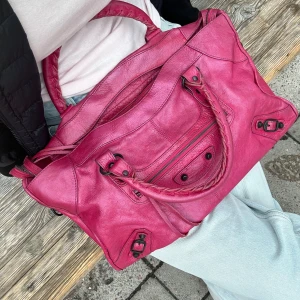  Balenciaga city bag rosa  - Säljer nu min balenciaga city bag i bra skick, säljer då det inte ritkigt var min färg! Storlek medium och får plats med dator etc utan problem! Riktig statement piece i garderoben💕 Priset går att diskutera vid snabb affär💕Köpt här på plick, säljer även på vinted och där går den att äkthetskolla om man vill det❤️