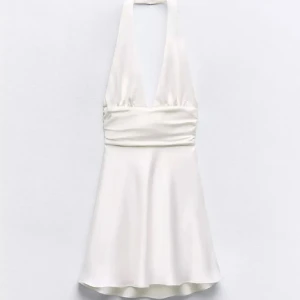 Vit satinklänning. - Fin vit satinklänning från Zara som aldrig är använd och har prislapp kvar. Zara är allmänt små i storlek så passar säkert även mindre!💗