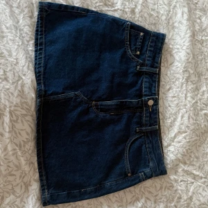 Mörkblå jeanskjol från Zara - Snygg mörkblå jeanskjol från Zara i klassisk femficksmodell. Kjolen har dragkedja och knapp framtill, samt två stora bakfickor. Perfekt för dig som gillar en enkel och tidlös stil. Passar till allt och är superenkel att styla. Den är som ny i skicket och endast använd fåtal gånger! Pm för fler bilder 🥰🥰!