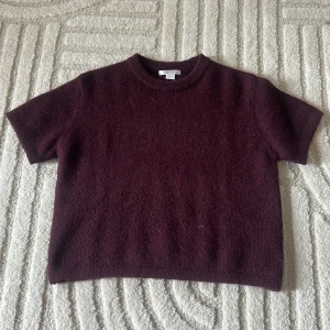 Vinröd stickad tröja från Gina Tricot - Mysig vinröd stickad tröja från Gina Tricot i kortärmad modell. Passar till mycket och använd ett fåtal gånger.