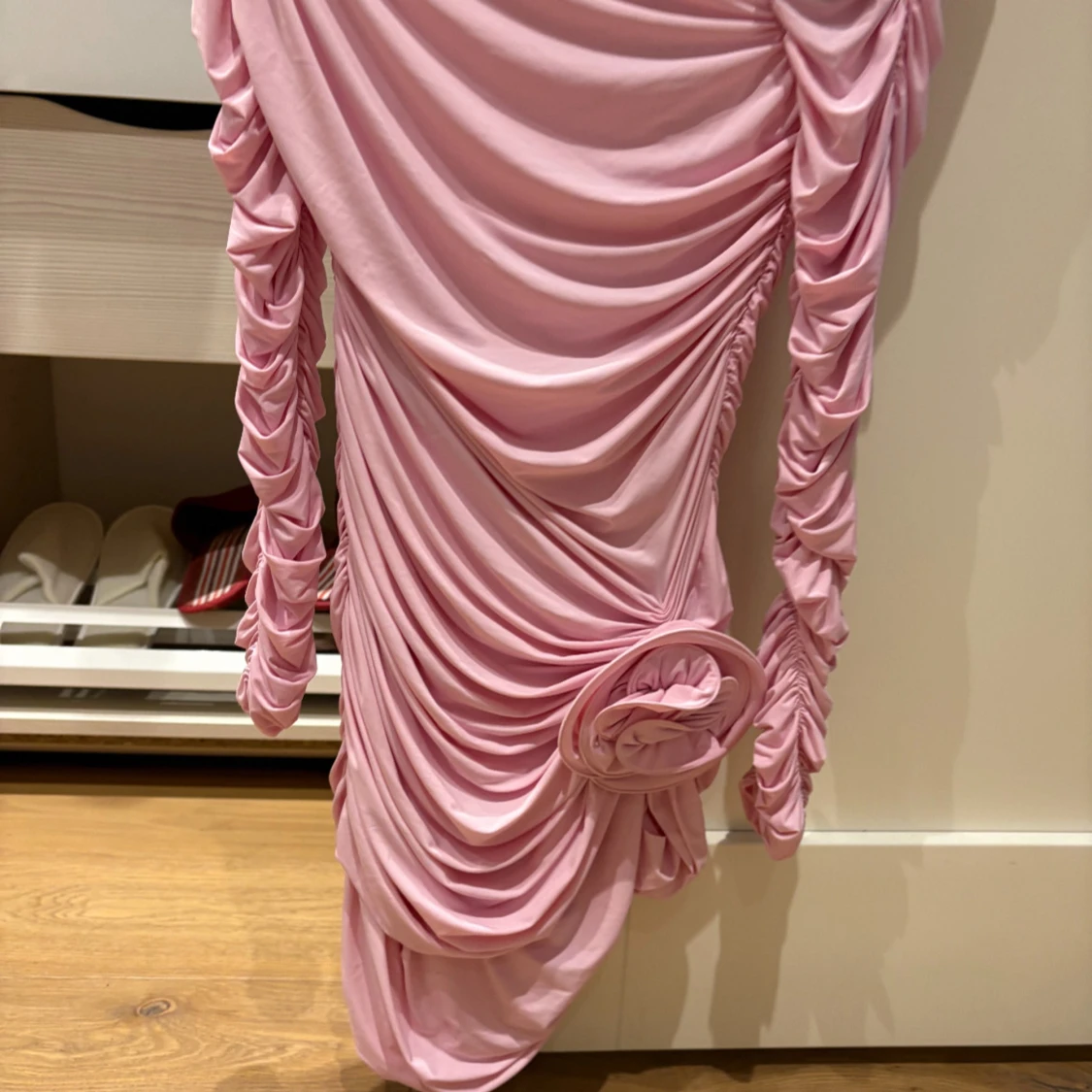 Ljusrosa draperad klänning med blomdetalj från H&M