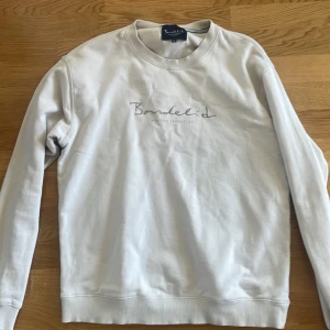 Beige sweatshirt från Bondelid - Säljer en stilren beige sweatshirt från Bondelid med broderad logga på bröstet. Tröjan har rund halsringning och långa ärmar. Perfekt för en avslappnad och snygg look. Pris kan diskuteras