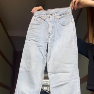 Ljusblå raka jeans från Levi's 26/30 - Ljusblå jeans från Levi's med klassisk femficksdesign och raka ben. W26 L30. Jeansen har hög midja och gylf med dragkedja och knapp. Perfekta för en avslappnad stil och passar till det mesta.