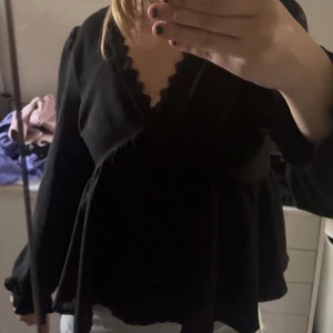 Svart blus med spetsdetaljer - Säljer en svart blus med v-ringning och fina spetsdetaljer längs halsringningen. Har använts endast några gånger! Den är i storlek S, Skriv vid frågor🎀 