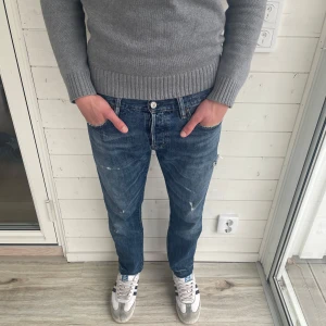 Ralph lauren jeans - Klassiska blå Ralph lauren jeans med raka ben. Jeansen har fem fickor, knappgylf och slitna detaljer för en cool, avslappnad look. Perfekta för dig som gillar vintagekänsla och tidlös stil. Jeansen är upp nopprade längst ner vid ben öppningen. Ytterbenslängd 96cm