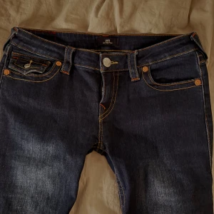 Mörkblå jeans från True Religion - säljer dessa jätte fina jeans från true religion. köpte de tidigare här på plick men de kommer ej till användning. de har detaljerade fickor och är utsvängda 💕💕