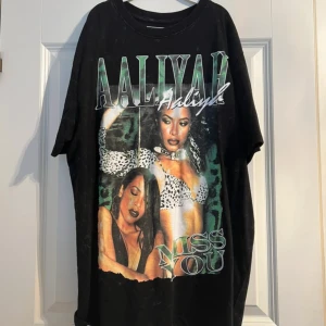 Svart oversized t-shirt med Aaliyah-tryck - Cool svart t-shirt med stort tryck av Aaliyah och texten 'Miss You' på framsidan. Oversized passform och korta ärmar, perfekt för en avslappnad streetstyle-look.