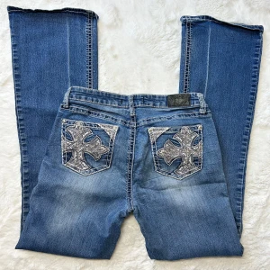 Lågmidjade bootcut jeans y2k  - Lågmidjade bootcut jeans med kors på bakfickorna. Storlek ”11” skulle säga att detta motsvarar en w29. Innerbenslängd: 80 midjemått:40.Köp sker via köp nu, jag postar inom 24h. Kvar tills markerad såld