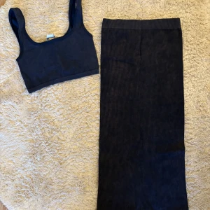 Mörkblått det från DİLÉVİN - Mörkblått ribbat set från DİLÉVİN. Kjolen och toppen har en tight passform och är tillverkad i ett stretchigt, ribbat material. Använd en gång. 