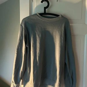 Grå sweatshirt från H&M - En enkel och stilren grå sweatshirt från H&M med relaxed fit. Tröjan har rund halsringning och långa ärmar. Perfekt för en avslappnad look och passar till det mesta i garderoben.