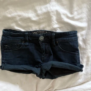 Vintage Lågmidjade jeansshorts - Säljer ett par korta Lågmidjade shorts med uppvikta ben. Vintage så svåra att få tag på. Tar inte emot prisförslag under 500kr.💞