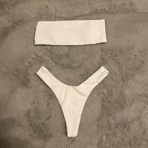 Bandeau Highwaisted Bikini  - Trendig Bandeau som är högmidjat i vitt och i storlek xs 👙Bikini toppen: Byst 64cm, Underbyst 60cm, Kupa 70A och under. Bikini underdel: Midja 64-90. Det finns padding man kan ta ut om man vill också som man ser på bild 3. Aldrig använt, inga defekter, endast testad och tvättad! Säljer den för toppen är för liten för mig. ❌Visar inte bikinin på mig❌