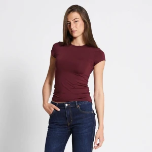 Vinröd tight t-shirt - En enkel och stilren vinröd t-shirt med tight passform och korta ärmar. Helt ny aldrig använd pga storleken passar inte mig. 