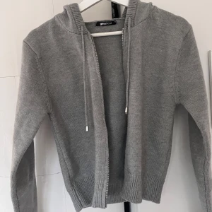 Grå stickad zip up hoodie  - Säljer en grå stickad zip up hoodie från Gina tricot då den ej kommit till användning. Använd väldigt sällan så väldigt bra skick! 