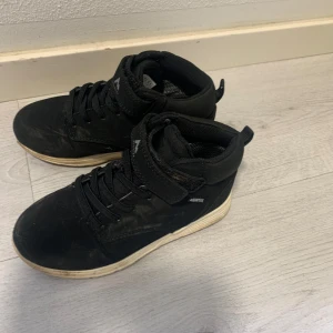 Svarta sneakers från McKinley - Säljer ett par svarta sneakers från McKinley, modell Richard AQX JR. Skorna har snörning och kardborreband för extra stöd. Perfekta för vardagsbruk med en bekväm passform.