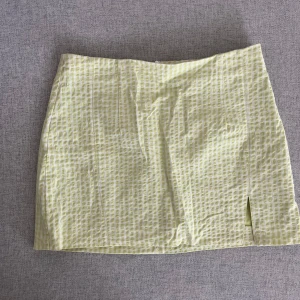 Grön och vit rutig kjol från Zara - Säljer en söt gul och vit rutig kjol från Zara. Kjolen har en liten slits på framsidan och en dragkedja bak för enkel påklädning. Perfekt för en solig dag! 🌼