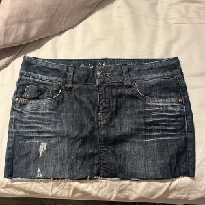 lågmidjad Jeanskjol i mörk denim - med lite nitar från esprit !! står storlek 27 passar nån som bär S