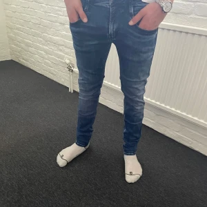 Replay ANBASS  - Snygga blå jeans från Replay med en modern tvätt och klassisk femficksdesign. Jeansen har en slim passform och är tillverkade i ett stretchigt material för extra komfort. Perfekta för en stilren look. Storlek är 29/32.