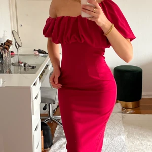 Rosa offshoulder klänning - Säljer en snygg rosa offshoulder klänning med volangdetaljer. Klänningen har en tight passform och är perfekt för festliga tillfällen. Den är endast använd ett fåtal gånger och är i bra skick💗
