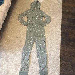 En onesie pyjamas  - En super söt onesie pyjamas från Kappahl med bakelser på i storlek 158/164, knappast använd bara några fåtal gånger.