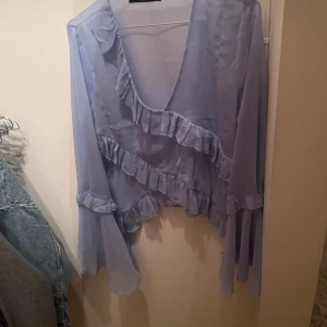 Blå volang blus - En ljusblå volang transparent blus från bikbok