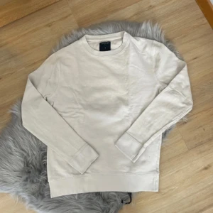 Beige tröja från The Black Label Collection - Säljer en stilren beige tröja från The Black Label Collection. Tröjan har långa ärmar och en klassisk rund halsringning. Perfekt för en avslappnad look. 🧥