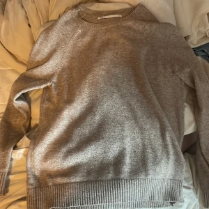 Beige stickad tröja från ONLY - Mysig beige stickad tröja från ONLY med rund halsringning och ribbade muddar vid ärmslut och nederkant. Perfekt för lager-på-lager och enkel att matcha med olika outfits. Lite nopprig men inget man tänker på.