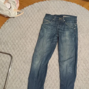  jeans från Levis - Klassiska blå jeans från Levis med fem fickor och snygga slitningar. 
