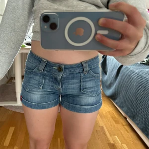 Blå jeansshorts med uppvikta ben - Säljer ett par blå lågmidjade jeansshorts med snygga detaljer på bakfickorna, är i mycket fint skick från edc by espri💕