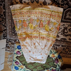 Blommig kjol i bomull - Säljer en vintageinspirerad kjol med blommigt mönster i orange, gul och vit. Kjolen har en A-linjeform och resår i midjan. Perfekt för dig som gillar retrostil och färgglada plagg.