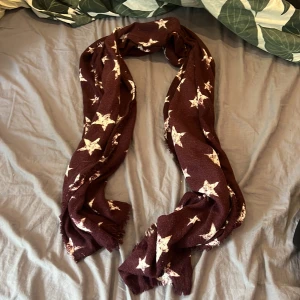  halsduk med stjärnmönster - Säljer denna mörk lila halsduk. Använt få tal gånger. Jätte fin!